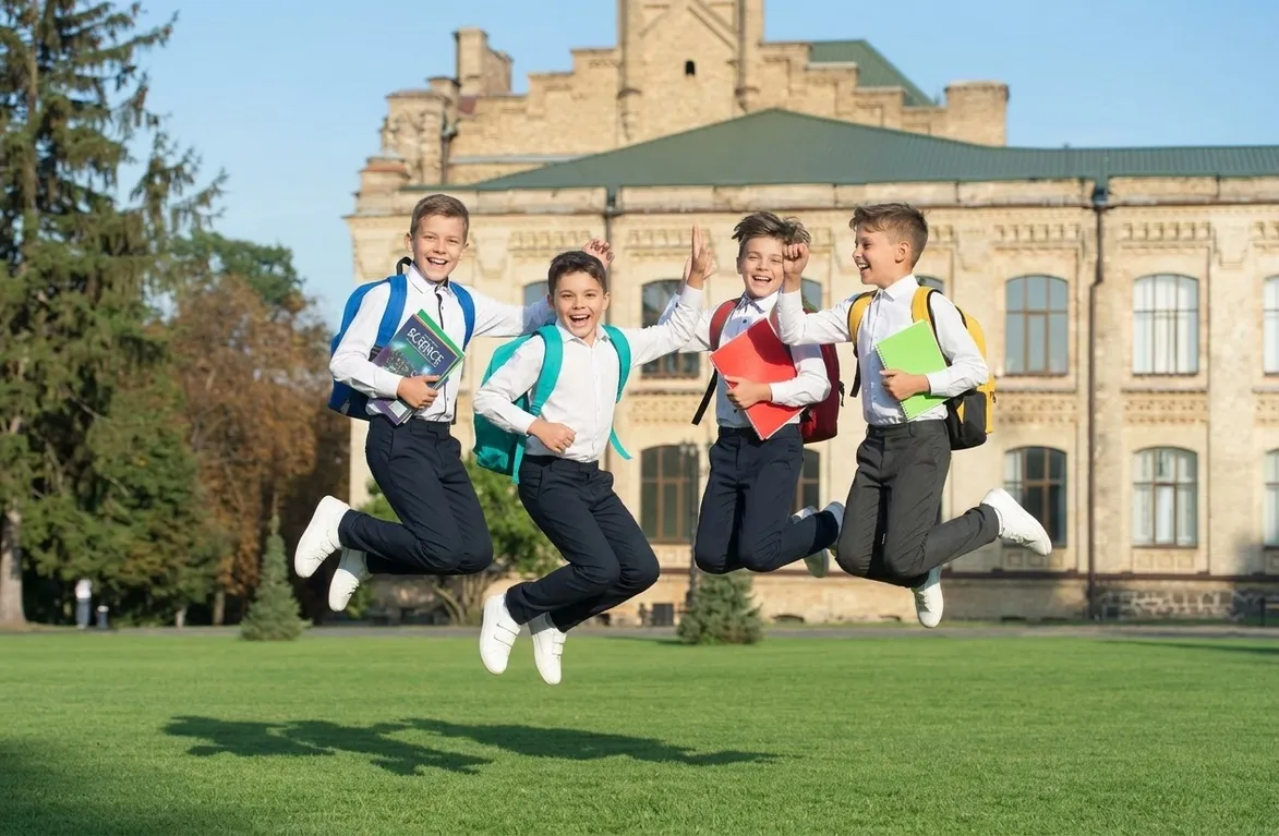 Students running on a school campus lawn